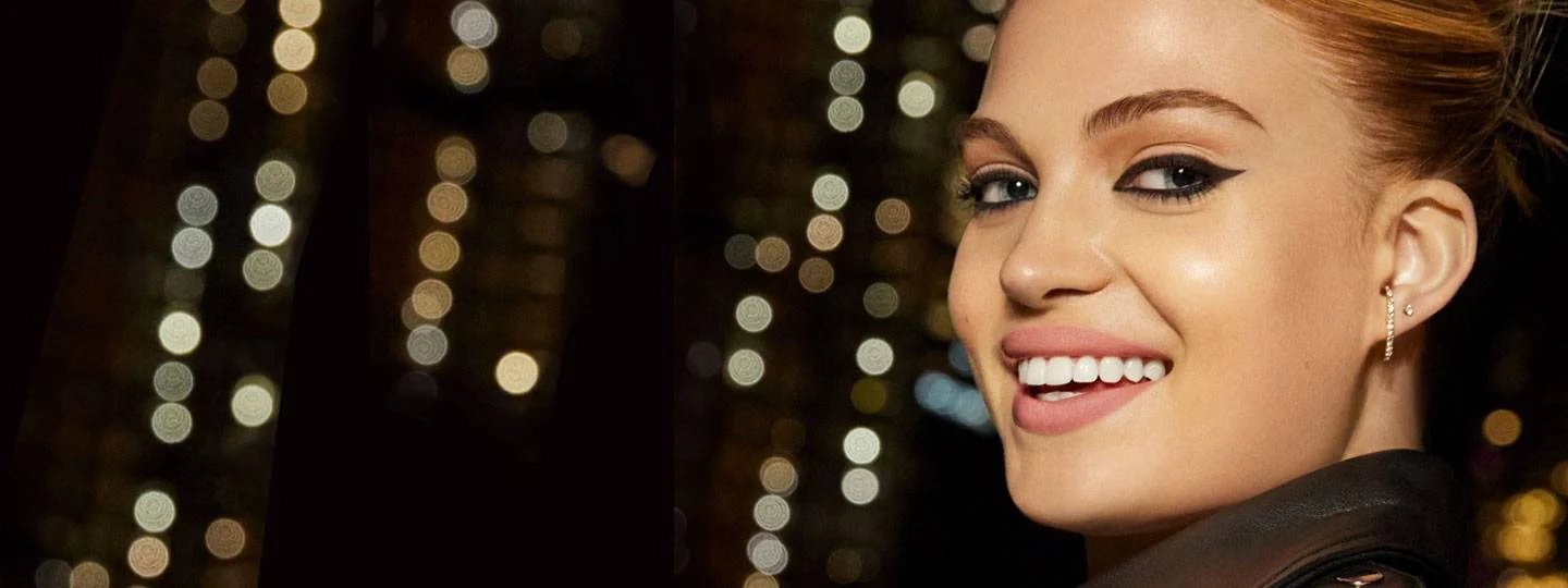 Leende kvinna - stadsljus i bakgrunden